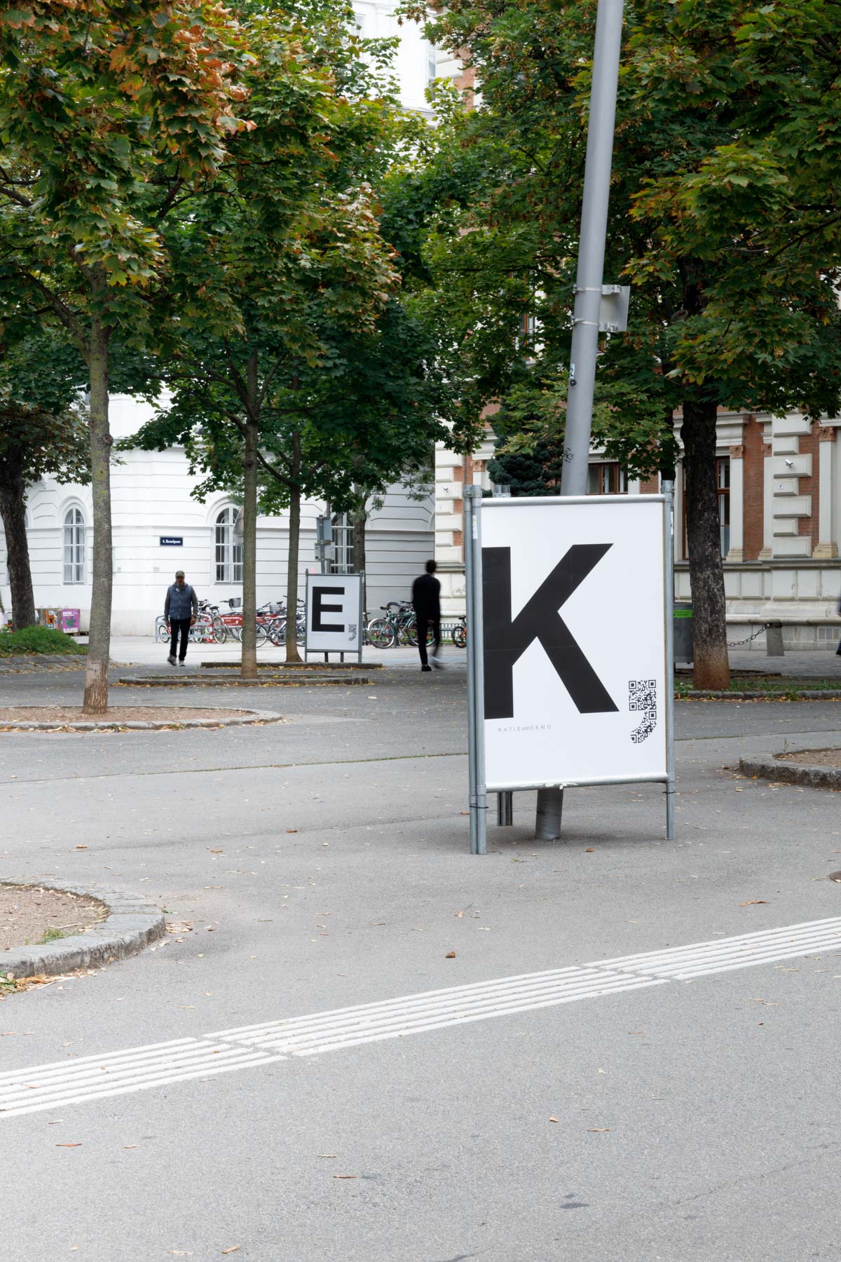 Wir Hier with God’s Entertainment ‚D, E, M, O, K, R, A, T, I und E‘ (installation view Karlsplatz) 2025.